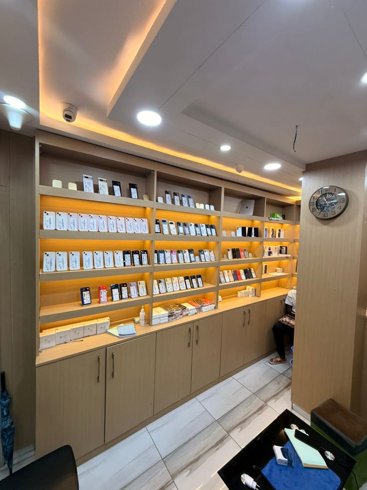 Le mur d’iPhone de la boutique, quatre rangées d’étagères éclairées