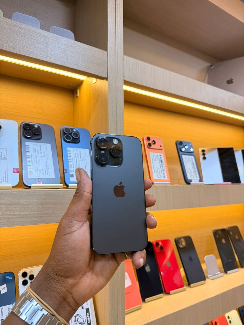 iPhone 14 Pro noir sidéral, vu de dos, tenu en main dans la boutique